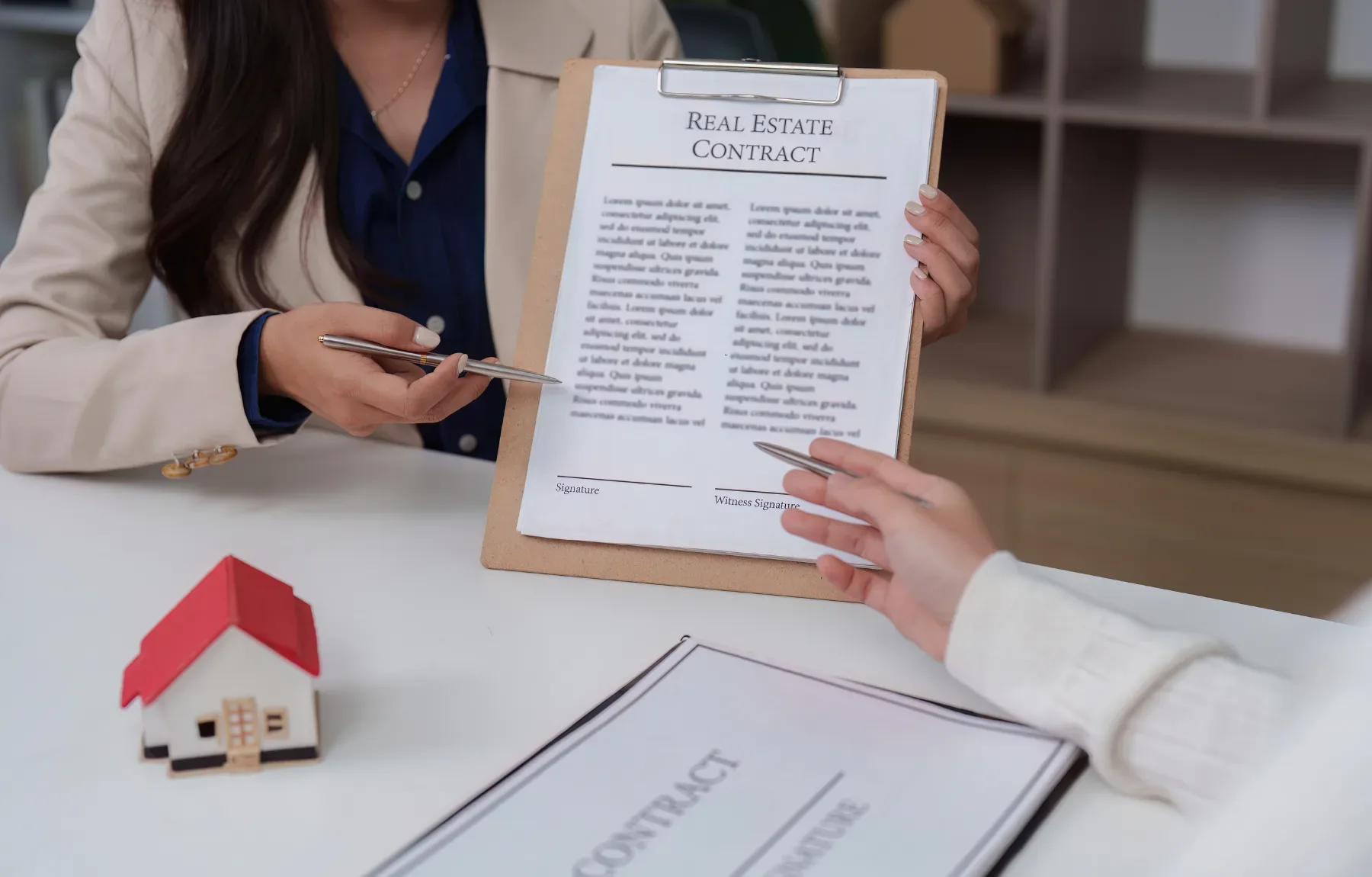 Professional real estate agent presenting a signed contract to a client during a property transaction meeting.